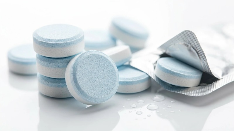 Pressed white and blue cleaning tablets with foil pack